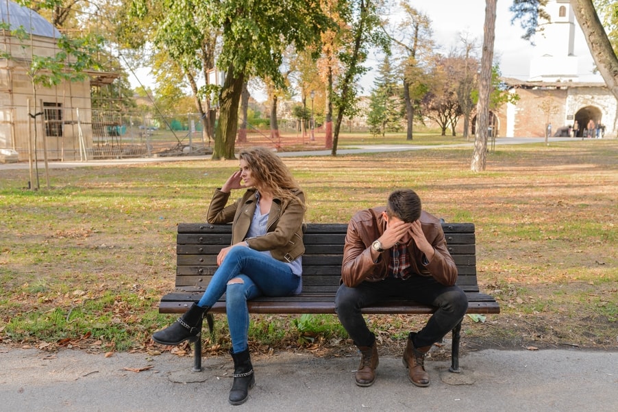 Upset couple on a park bench considering using the Collaborative Divorce Process.